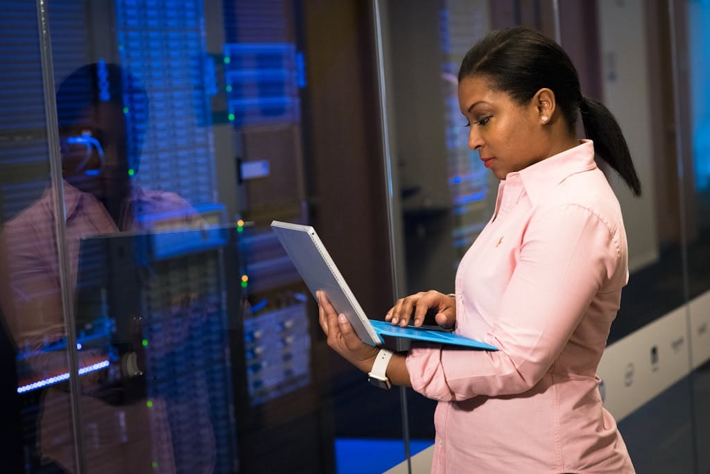Telecommunication 11 A focused software engineer working on a laptop in a server room, reflecting dedication in tech.
