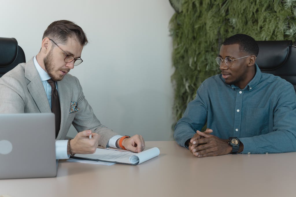 Retail & CPG 13 A professional job interview between two men in a modern office environment.