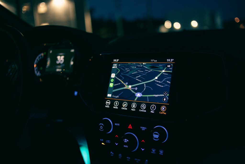 Automotive 11 Interior view of a car featuring the GPS navigation system illuminated at night, showcasing technology and modern travel.