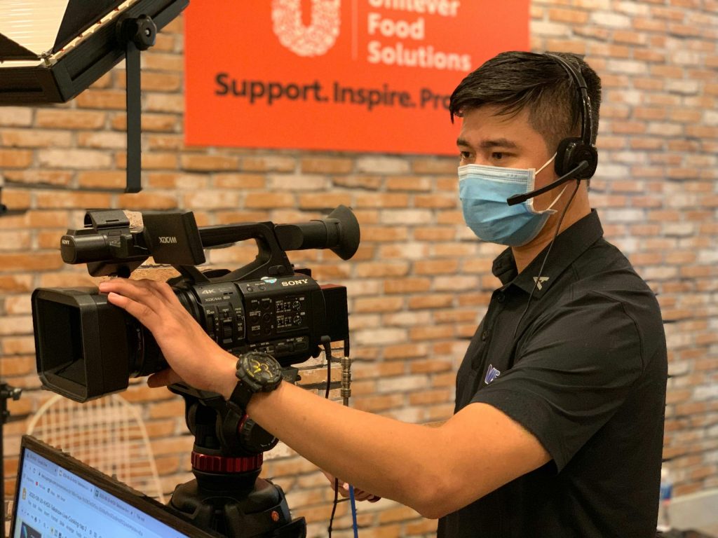 Media & Entertainment 11 Professional videographer with headset operating camera in an indoor studio setting.